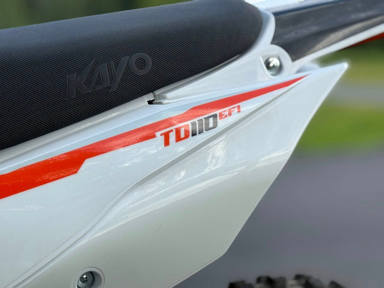 The Kayo TD110 EFI Pit Bike features a sleek, aggressive design with a black and red color scheme, inverted front forks, knobby off-road tires, and a high-mounted exhaust. The EFI fuel system, hydraulic disc brakes, and reinforced steel frame make this mini dirt bike a top choice for performance-oriented riders