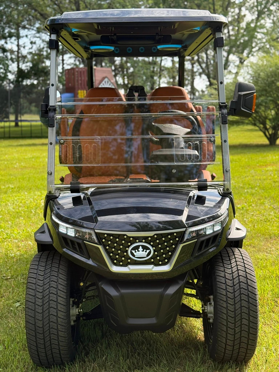 Evolution D-MAX GT4 luxury electric golf cart with forward-facing design, black automotive-grade seats, 10.1-inch touchscreen with CarPlay, 24-speaker audio system, LED lighting, and aluminum wheels, built for performance and style.