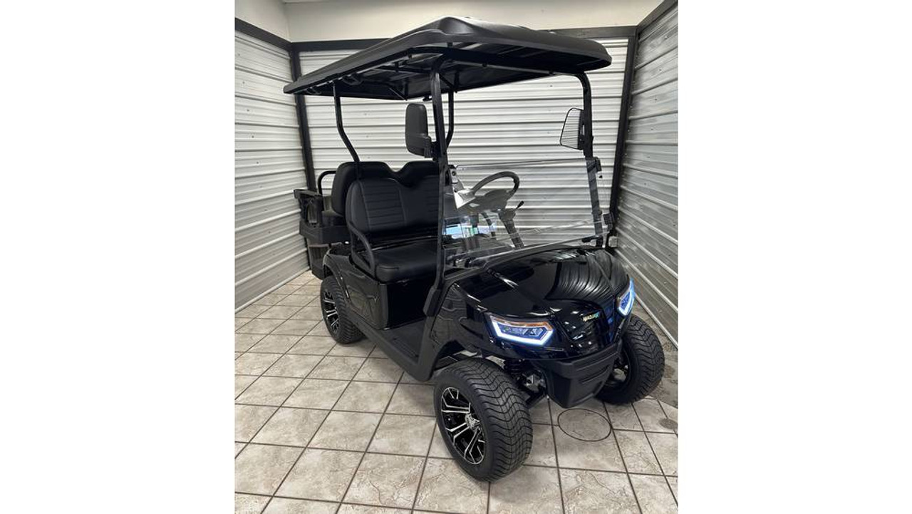 The 2025 MadJax E Series Golf Cart boasts a sleek, modern design with LED lighting, a 7" LCD display, and stylish GTW wheels. The spacious interior includes dual USB ports, comfortable seating, and smart storage. Powered by a zero-maintenance Eco Lithium battery, this cart delivers extended range and unbeatable value.