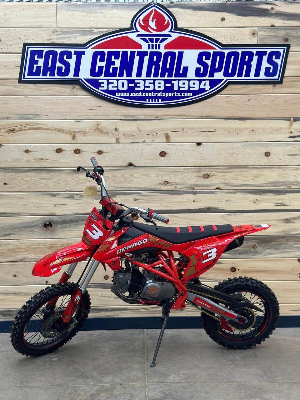 Denago MX3 Red Edition 140cc Pit Bike with bold red graphics, black powder-coated wheels, stainless steel exhaust, gold drive chain, and CNC anodized components for trail and off-road riding.