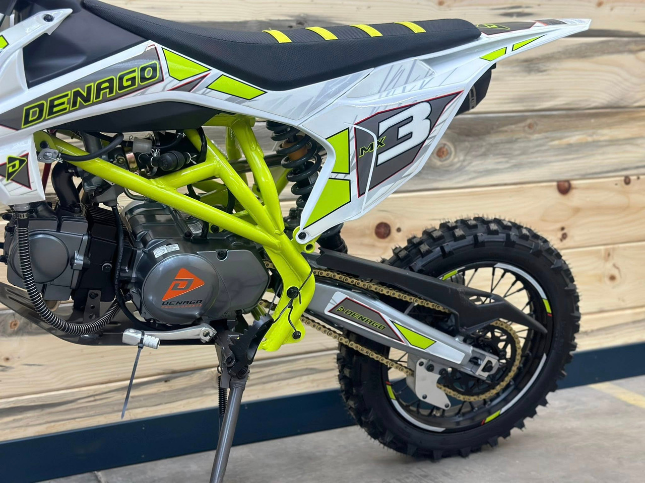 "The Denago MX3 Lime Edition pit bike features a 140cc engine with 4-speed transmission, hydraulic disc brakes, and adjustable suspension. Shown with vibrant lime green accents on CNC components, black powder-coated wheels, and aggressive knobby tires, this performance bike offers inverted forks, folding levers, and stainless exhaust. Perfect for serious trail riding with 14.5" ground clearance." "The Denago MX3 Lime Edition pit bike features a 140cc engine with 4-speed transmission, hydraulic disc brakes, and adjustable suspension. Shown with vibrant lime green accents on CNC components, black powder-coated wheels, and aggressive knobby tires, this performance bike offers inverted forks, folding levers, and stainless exhaust. Perfect for serious trail riding with 14.5" ground clearance."