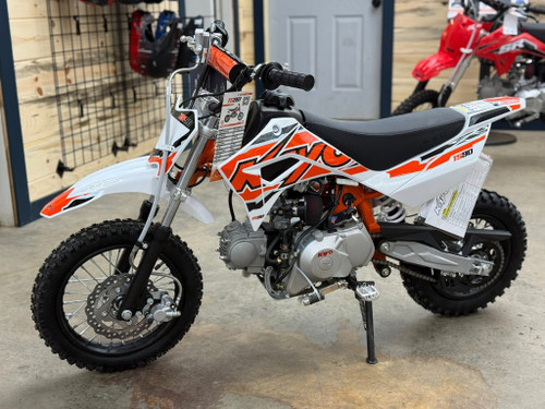 The image showcases the Kayo TS90 90cc Pit Bike, a sleek and agile off-road machine designed for riders of all skill levels. The bike features a compact and lightweight design with a 24.6-inch seat height, making it accessible to a wide range of riders. The 86cc 4-stroke engine and electric/kick start system are highlighted, emphasizing the bike's ease of use and reliability. The front and rear disc brakes are visible, showcasing the bike's safety features. The 12-inch front tire and 10-inch rear tire provide excellent traction and stability, while the conventional front forks and single rear shock ensure a smooth and comfortable ride. The low tack seat cover adds comfort and grip, and the 7-inch ground clearance allows the bike to tackle rough terrains with ease. Overall, the image captures the essence of a versatile, high-performing, and fun pit bike ready for any off-road adventure. The image showcases the Kayo TS90 90cc Pit Bike, a sleek and agile off-road machine designed for riders of all skill levels. The bike features a compact and lightweight design with a 24.6-inch seat height, making it accessible to a wide range of riders. The 86cc 4-stroke engine and electric/kick start system are highlighted, emphasizing the bike's ease of use and reliability. The front and rear disc brakes are visible, showcasing the bike's safety features. The 12-inch front tire and 10-inch rear tire provide excellent traction and stability, while the conventional front forks and single rear shock ensure a smooth and comfortable ride. The low tack seat cover adds comfort and grip, and the 7-inch ground clearance allows the bike to tackle rough terrains with ease. Overall, the image captures the essence of a versatile, high-performing, and fun pit bike ready for any off-road adventure.