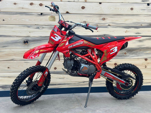 Denago MX3 Red Edition 140cc Pit Bike with bold red graphics, black powder-coated wheels, stainless steel exhaust, gold drive chain, and CNC anodized components for trail and off-road riding.