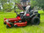 Toro Timecutter 42" Fab Deck (77404), a robust zero-turn riding mower with a sleek red and black design. The mower features a step-through front end, handcrafted comfort seat, and IronForged® 10-gauge steel deck. The dual hydrostatic transmission and Smart Speed® Technology are highlighted, emphasizing the mower's precision and control. The protective tire fenders and under-seat storage cubby add to its functionality, while the 22 hp Briggs & Stratton engine underscores its power and reliability.