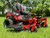 I-Beam Front End Close-Up:
A close-up shot of the TITAN’s commercial-style I-beam front end, showcasing its rugged, heavy-duty construction. The thick steel beams are built to withstand extreme conditions, ensuring unmatched durability and strength for tackling the toughest mowing jobs.

MyRIDE® Suspension System:
A detailed image of the patented MyRIDE® Suspension System, featuring a large spring coil isolated from the mower frame. This innovative design absorbs shocks and vibrations, providing a smooth, comfortable ride even on rough terrain.

IronForged® Deck:
A close-up of the 54-inch IronForged® deck, highlighting its heavy-duty 10-gauge steel construction. The reinforced belts, beefy leading edge, and massive spindles are visible, showcasing the deck’s ability to handle rocks, roots, and thick grass without flinching.

Rear Tires:
A side view of the TITAN’s 22-inch rear tires, emphasizing their aggressive tread pattern. These massive tires are designed for maximum traction, ensuring the mower can power through steep hills, wet grass, and uneven terrain with ease.

Front Caster Tires:
A close-up of the 13-inch treaded front caster tires, showcasing their rugged design. The treads add stability and grip, while the pneumatic construction ensures a smooth ride over obstacles.

Gaming-Style Seat:
A detailed shot of the 20-inch gaming-style seat, featuring black upholstery with red side stripes. The ergonomic design provides exceptional lumbar support and comfort, making long mowing sessions feel effortless.

Rubber Discharge Chute:
A close-up of the commercial-style rubber discharge chute, highlighting its flexibility and durability. The chute bends without breaking, allowing for precise trimming close to landscaping features without causing damage.

MyToro App Icon:
A digital image of the MyToro App icon, displayed on a smartphone screen. The app provides easy access to manuals, how-to videos, service reminders, and more, making it a must-have tool for TITAN owners.

Full Machine Overview:
A wide-angle shot of the 2024 Toro TITAN 54" MyRIDE Zero Turn Mower in action, cutting through a lush, green lawn. The mower’s sleek design, reinforced bullnose bumper, and aggressive stance are on full display, showcasing its power and dominance.

Cast Aluminum Stomp Pad:
A close-up of the cast aluminum stomp pad, located near the mower’s step-up area. The textured surface provides a secure grip for scraping boots and stepping onto the machine, adding both functionality and durability.

Height-of-Cut Adjustment:
A detailed image of the drop pin height-of-cut system, showing the easy-to-use adjustment mechanism. This professional-grade feature allows for quick and precise height adjustments, ensuring a perfect cut every time.

Engine Close-Up:
A close-up of the 26 HP Kohler KT745 engine, highlighting its robust design and air-cooled system. The engine’s power and reliability are evident, making it the heart of the TITAN’s unmatched performance.