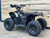 The image features the Denago E-Hawk 6 ATV, a sleek and modern electric ATV designed for kids aged 6 and up. The ATV showcases a bold black finish with multicolored LED lights, giving it a stylish and futuristic look. The rugged all-terrain tires (AT 16 x 8-7) and double A-arm front suspension highlight its capability to handle various terrains, from dirt trails to grassy fields. The handlebar-mounted controls, including the push-button gear selector and keyed ignition, are clearly visible, emphasizing the ATV's user-friendly design. The compact dimensions (51" x 31" x 32.5") and low seat height (23.5") make it perfectly sized for young riders, while the 48V removable lithium-ion battery and 1600W brushless electric motor underscore its eco-friendly and high-performance features. Safety elements like dual hydraulic disk brakes and an anti-theft alarm are subtly integrated into the design. This image captures the essence of the E-Hawk 6 ATV as a safe, fun, and technologically advanced electric vehicle for kids.
