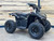 The image features the Denago E-Hawk 6 ATV, a sleek and modern electric ATV designed for kids aged 6 and up. The ATV showcases a bold black finish with multicolored LED lights, giving it a stylish and futuristic look. The rugged all-terrain tires (AT 16 x 8-7) and double A-arm front suspension highlight its capability to handle various terrains, from dirt trails to grassy fields. The handlebar-mounted controls, including the push-button gear selector and keyed ignition, are clearly visible, emphasizing the ATV's user-friendly design. The compact dimensions (51" x 31" x 32.5") and low seat height (23.5") make it perfectly sized for young riders, while the 48V removable lithium-ion battery and 1600W brushless electric motor underscore its eco-friendly and high-performance features. Safety elements like dual hydraulic disk brakes and an anti-theft alarm are subtly integrated into the design. This image captures the essence of the E-Hawk 6 ATV as a safe, fun, and technologically advanced electric vehicle for kids.