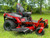Toro 50" TimeCutter Max MyRide Zero Turn Mower (77502), highlighting its innovative MyRIDE® Suspension System with a close-up of the large spring coil. This feature isolates the operator from rough terrain, providing a smooth and comfortable ride while mowing. The mower’s heavy-duty steel IronForged® Deck is prominently displayed, emphasizing its durability and ability to handle tough mowing conditions. The beefy hybrid-tread rear tires are shown for maximum traction, ensuring the mower can navigate any terrain without damaging the turf. Additionally, the image highlights the spray-blocking fenders, which prevent debris and water from splashing onto the engine or operator. The automotive-style fuel fill and integrated drain hose are also visible, showcasing the mower’s user-friendly maintenance features. With its ultra-strong, fully tubular steel frame and 23 hp Kawasaki engine, this zero-turn mower is designed for professional-grade performance and residential comfort.