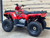 Odes Angler 120cc EFI Youth ATV in a vibrant red and black color scheme, highlighting its sleek and rugged design. The ATV is positioned on a dirt trail, emphasizing its off-road capabilities. Key features such as the front and rear racks, durable wheels, and ergonomic seat are clearly visible, making it evident that this ATV is built for adventure. The image also highlights the ATV's compact size, making it ideal for young riders.