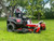 Toro TimeCutter 42" Fab Deck with MyRIDE Suspension, a zero-turn mower designed for residential lawn care. The mower features a sleek, durable design with a 42-inch IronForged® steel deck, a handcrafted high-back seat with armrests, and protective fenders. The MyRIDE® Suspension System is prominently highlighted, emphasizing its ability to provide a smooth, comfortable ride over rough terrain. The mower's compact size and commercial-grade engine make it ideal for properties up to 2 acres. The image also highlights the built-in cup holder and tool-less belt cover, showcasing the mower's user-friendly features.