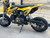 "The Denago MX Yellow Edition pit bike features a 110cc engine with electric start, automatic transmission, and hydraulic disc brakes. Shown with vibrant yellow accents on CNC components, black powder-coated wheels, and aggressive knobby tires, this beginner-friendly bike offers adjustable suspension and foldable levers. Perfect for trails and backyard riding with its 24" seat height."