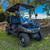 RedDot 1/4" tinted folding windshield installed on an Evolution D5 Ranger/Maverick golf cart. The photo highlights the thick acrylic material, folding capability, and UV-resistant tinted finish, designed for weather protection and enhanced driver comfort.