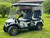 Evolution D-MAX GT4 luxury electric golf cart with forward-facing design, black automotive-grade seats, 10.1-inch touchscreen with CarPlay, 24-speaker audio system, LED lighting, and aluminum wheels, built for performance and style.