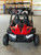 The image showcases the Hammerhead by Polaris MudHead SE, a sleek and stylish go-kart designed for young adventurers aged 10 and up. The go-kart features a modern design with upgraded plastic body panels and a steel bumper, emphasizing its durability and style. The 208cc LCT electric-start engine is highlighted, showcasing the go-kart's power and ease of use. The dual LED headlights and canopy top are visible, adding to the go-kart's functional and stylish design. The ROPS roll cage and three-point safety belts are prominently displayed, underscoring the go-kart's commitment to safety. The 16-inch tires and rear hydraulic disc brake ensure excellent traction and reliable stopping power. Overall, the image captures the essence of a safe, durable, and fun go-kart ready for endless adventures.