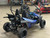 The image showcases the Hammerhead by Polaris MudHead SE, a sleek and stylish go-kart designed for young adventurers aged 10 and up. The go-kart features a modern design with upgraded plastic body panels and a steel bumper, emphasizing its durability and style. The 208cc LCT electric-start engine is highlighted, showcasing the go-kart's power and ease of use. The dual LED headlights and canopy top are visible, adding to the go-kart's functional and stylish design. The ROPS roll cage and three-point safety belts are prominently displayed, underscoring the go-kart's commitment to safety. The 16-inch tires and rear hydraulic disc brake ensure excellent traction and reliable stopping power. Overall, the image captures the essence of a safe, durable, and fun go-kart ready for endless adventures.