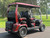 Evolution D-MAX GT4 luxury electric golf cart with forward-facing design, black automotive-grade seats, 10.1-inch touchscreen with CarPlay, 24-speaker audio system, LED lighting, and aluminum wheels, built for performance and style.