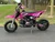 Pink 2026 Denago MX 110cc class dirt bike side view