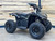 The image features the Denago E-Hawk 6 ATV, a sleek and modern electric ATV designed for kids aged 6 and up. The ATV showcases a bold black finish with multicolored LED lights, giving it a stylish and futuristic look. The rugged all-terrain tires (AT 16 x 8-7) and double A-arm front suspension highlight its capability to handle various terrains, from dirt trails to grassy fields. The handlebar-mounted controls, including the push-button gear selector and keyed ignition, are clearly visible, emphasizing the ATV's user-friendly design. The compact dimensions (51" x 31" x 32.5") and low seat height (23.5") make it perfectly sized for young riders, while the 48V removable lithium-ion battery and 1600W brushless electric motor underscore its eco-friendly and high-performance features. Safety elements like dual hydraulic disk brakes and an anti-theft alarm are subtly integrated into the design. This image captures the essence of the E-Hawk 6 ATV as a safe, fun, and technologically advanced electric vehicle for kids.