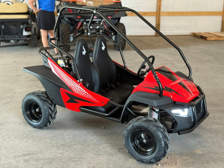The image showcases the Hammerhead by Polaris MudHead SE, a sleek and stylish go-kart designed for young adventurers aged 10 and up. The go-kart features a modern design with upgraded plastic body panels and a steel bumper, emphasizing its durability and style. The 208cc LCT electric-start engine is highlighted, showcasing the go-kart's power and ease of use. The dual LED headlights and canopy top are visible, adding to the go-kart's functional and stylish design. The ROPS roll cage and three-point safety belts are prominently displayed, underscoring the go-kart's commitment to safety. The 16-inch tires and rear hydraulic disc brake ensure excellent traction and reliable stopping power. Overall, the image captures the essence of a safe, durable, and fun go-kart ready for endless adventures.