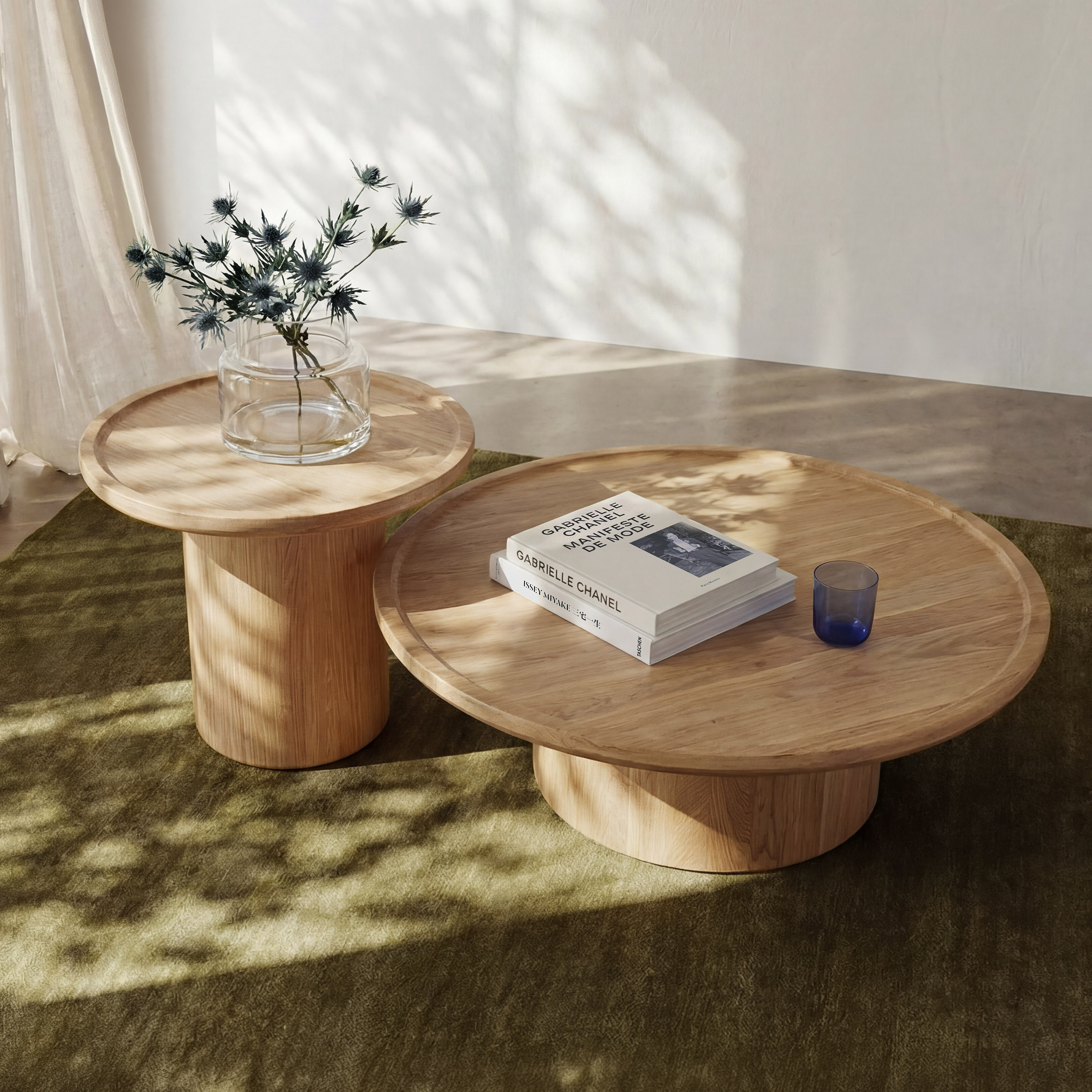 a wooden table with a glass vase and a small box with a plant in it