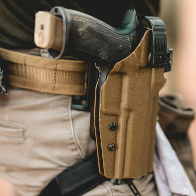 DARA DBL2 Holster Attachment tan color with black pistol and belt clip, attached to khaki pants.