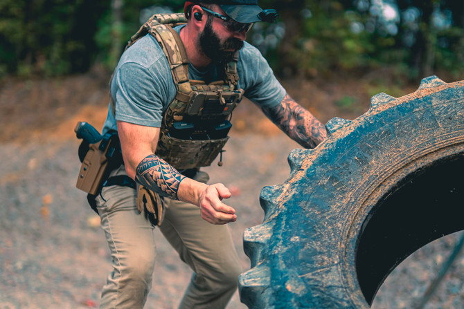 Dara Level 2 Duty Holster on a man's hip, outside with a tactical vest and gear.