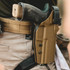 DARA DBL2 Holster Attachment tan color with gun installed on person's belt securely.