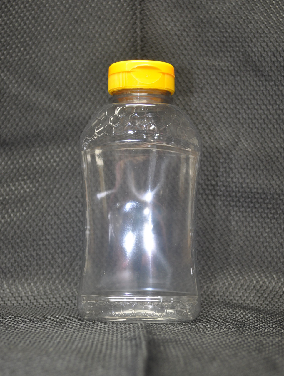 16 oz. (24 oz. Honey Weight) Ribbed Hourglass PET Honey Bottle with  Pressure Sensitive Liner Black Plastic Flip Top Lid