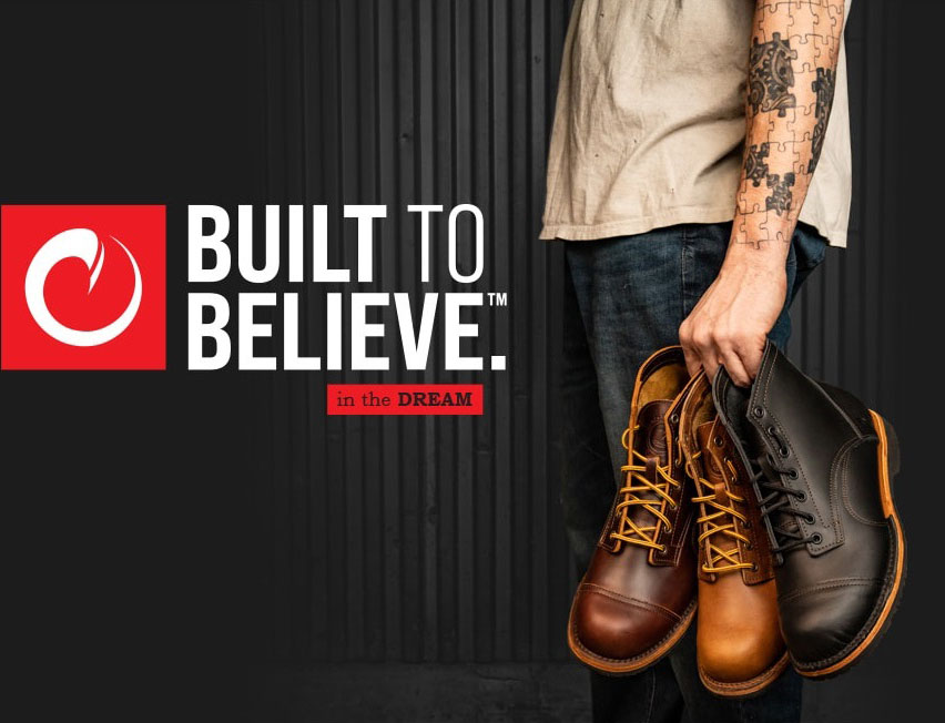 Man holding three leather boots that are dark brown, light brown, and black from left to right.