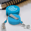 A blue retractable ID holder featuring a logo, equipped with a clip and a clear badge reel.