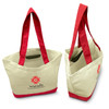 A canvas tote bag featuring a cream exterior with bright red handles and trim, along with a logo on the front.
