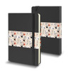 A medium black hard cover notebook with a patterned band featuring various cat illustrations.