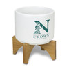 A white planter with a bamboo base, featuring a logo design.