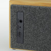 A Bluetooth speaker with a wooden frame and grey fabric covering, featuring various input ports.