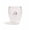 A double-walled glass cup with a transparent design and a logo featuring a mountain and palm tree.