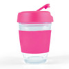 A reusable coffee cup with a clear body and a bright pink silicone sleeve and flip lid.