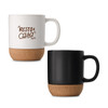 A ceramic mug with a cork base, available in white with text and a solid black version. Both feature a handle and a logo.