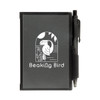 A black Odyssey Pocket Notebook featuring a design with "Beaking Bird" and accompanied by a pen attached to the cover.
