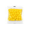 A clear cello bag filled with bright yellow jelly beans. The bag is sealed and contains various shaped candies.