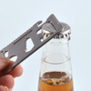 A silver multi-tool is positioned over a bottle cap, ready to open a beverage.