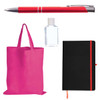 A red pen, a clear bottle of hand sanitizer, a pink tote bag, and a black notebook with an orange elastic band.