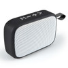A rectangular black and white portable speaker with a textured surface and a carrying strap.
