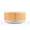 A round speaker and wireless charger with a bamboo timber exterior and a white base. The product features a logo.