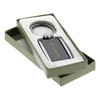 A sleek carbon fibre keychain in a gift box, featuring a branding logo and metallic accents.
