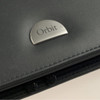 A black leather zippered compendium featuring a silver logo plate.