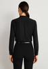 A black long sleeve blouse with a simple design and buttoned cuffs, viewed from the back.