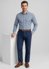 A man in a checkered shirt and brown belt poses in navy slacks, showcasing a sophisticated look.