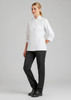 A model wears a white chef's jacket paired with black pants, showcasing a professional culinary uniform.