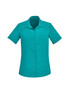 A plain short sleeve shirt in a vibrant teal colour, featuring a collar and a front pocket, with a logo.