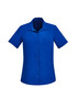 A blue short sleeve shirt with a collar and a front pocket, featuring a logo.
